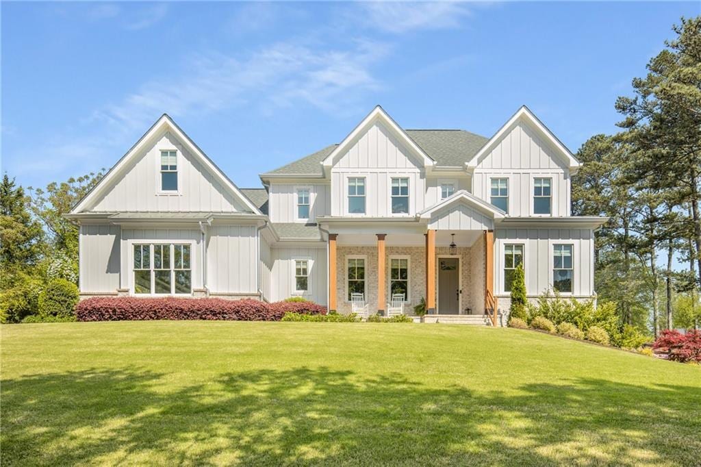 16050 Freemanville Rd, Milton, GA 30004 - view of front of home featuring board and batten siding, covered porch, and a front yard