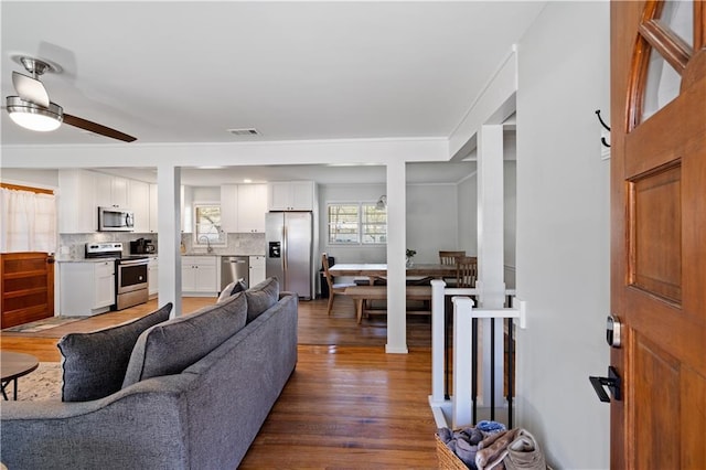 living room featuring ceiling fan, sink, and dark hardwood / wood-style flooring