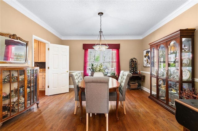 dining area featuring crown molding, light wood-type flooring, and a chandelier