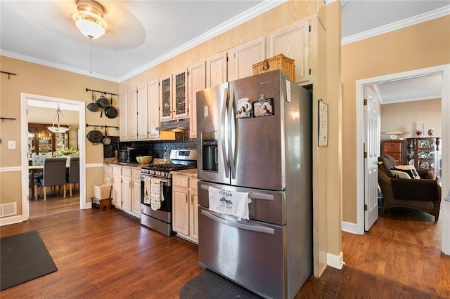 kitchen with visible vents, ornamental molding, dark wood-type flooring, under cabinet range hood, and appliances with stainless steel finishes