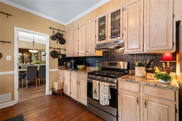 kitchen featuring stainless steel range with gas cooktop, tasteful backsplash, under cabinet range hood, visible vents, and ornamental molding