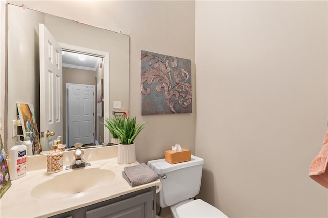 half bath with crown molding, toilet, and vanity