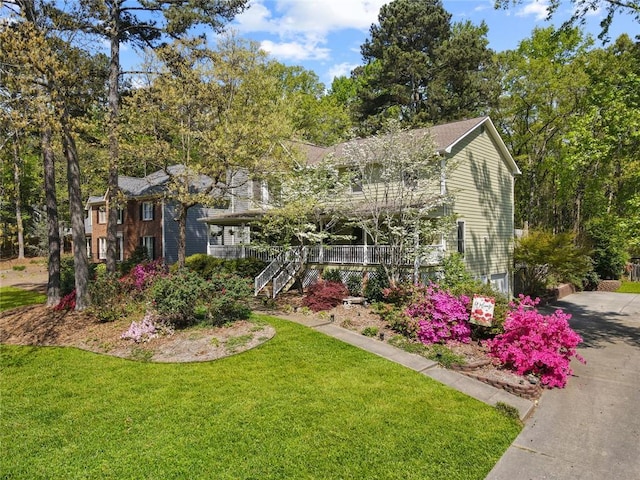 view of front of house with stairs, covered porch, and a front yard