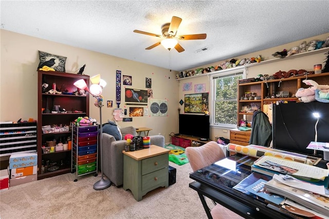 office featuring light colored carpet, a ceiling fan, a textured ceiling, and visible vents