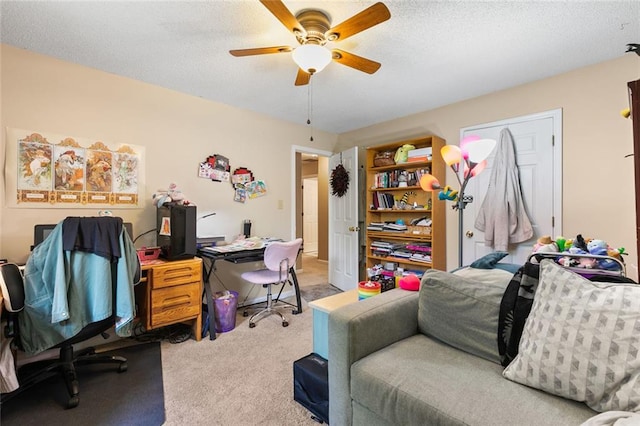carpeted office with a ceiling fan and a textured ceiling