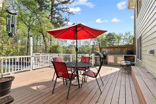 wooden deck featuring area for grilling and outdoor dining area