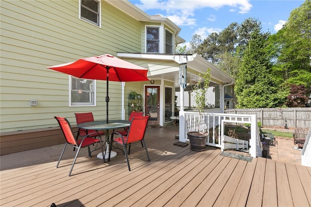 deck featuring outdoor dining area and fence