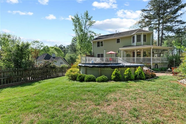 back of house featuring a fenced in pool, fence, a yard, and a chimney