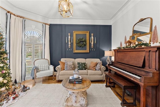 sitting room featuring a chandelier, hardwood / wood-style flooring, and crown molding