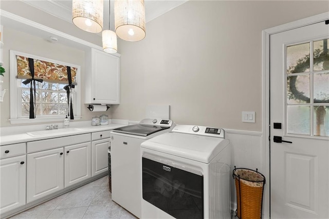 laundry area featuring washer and dryer, a healthy amount of sunlight, cabinets, and sink