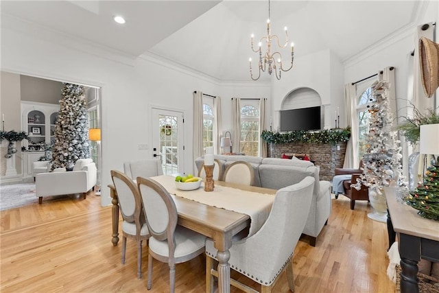 dining area featuring ornamental molding, a notable chandelier, and light wood-type flooring