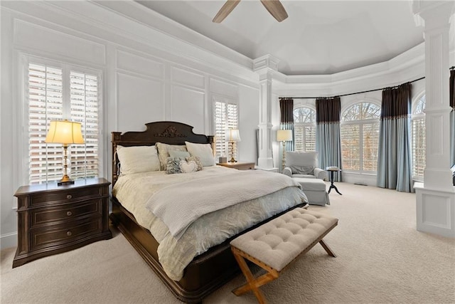 carpeted bedroom featuring ceiling fan, ornate columns, and a towering ceiling