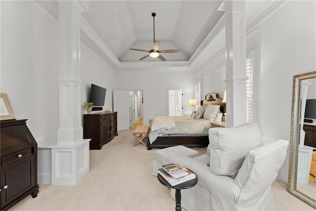 bedroom featuring ceiling fan, ornate columns, light carpet, and a tray ceiling