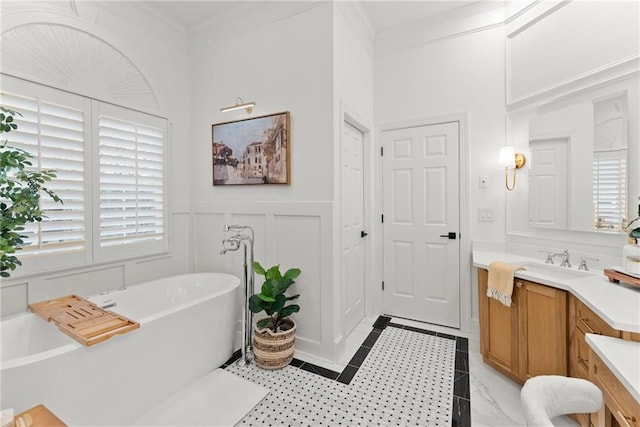 bathroom with a washtub, crown molding, and vanity