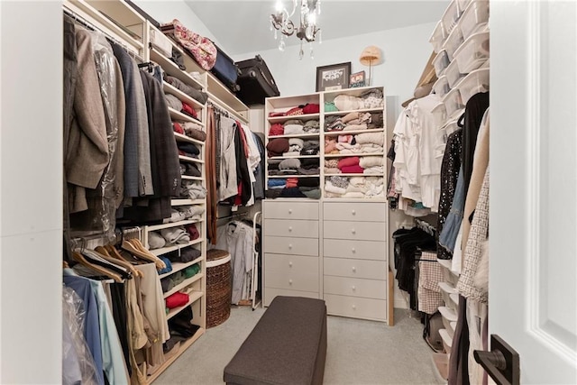 walk in closet featuring light colored carpet and a chandelier