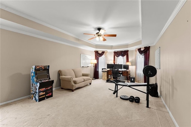 interior space with light carpet, a tray ceiling, ceiling fan, and ornamental molding