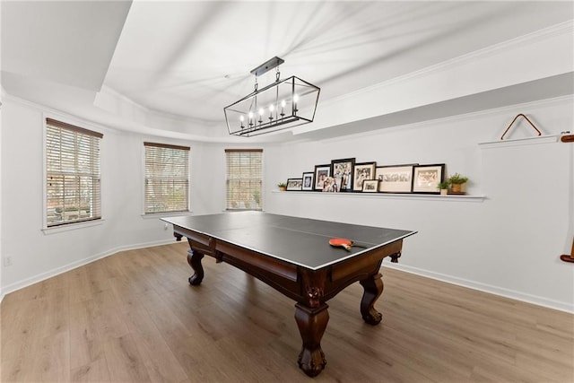 rec room with wood-type flooring, crown molding, and a tray ceiling