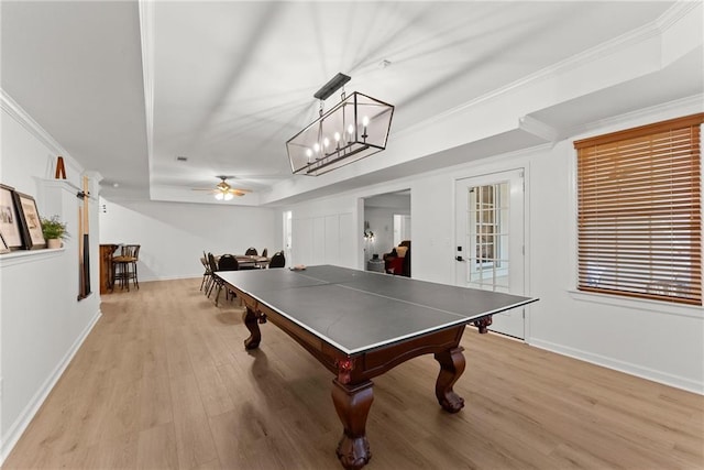 recreation room featuring a raised ceiling, ceiling fan, light hardwood / wood-style flooring, and ornamental molding