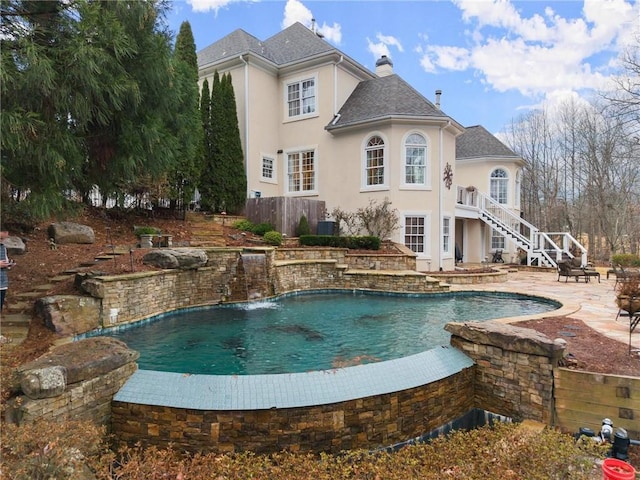 view of swimming pool with a patio and pool water feature