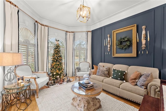 living room featuring a notable chandelier, crown molding, and light hardwood / wood-style flooring