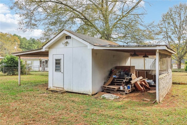 view of outbuilding with a lawn and a carport