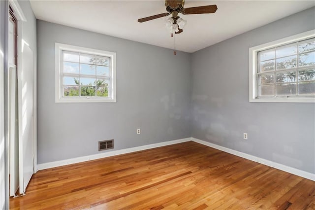 unfurnished room featuring wood-type flooring, ceiling fan, and a healthy amount of sunlight