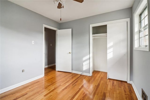 unfurnished bedroom with light wood-type flooring, a closet, and ceiling fan