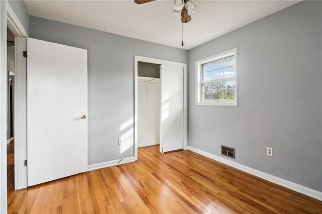 unfurnished bedroom with ceiling fan, a closet, and light wood-type flooring