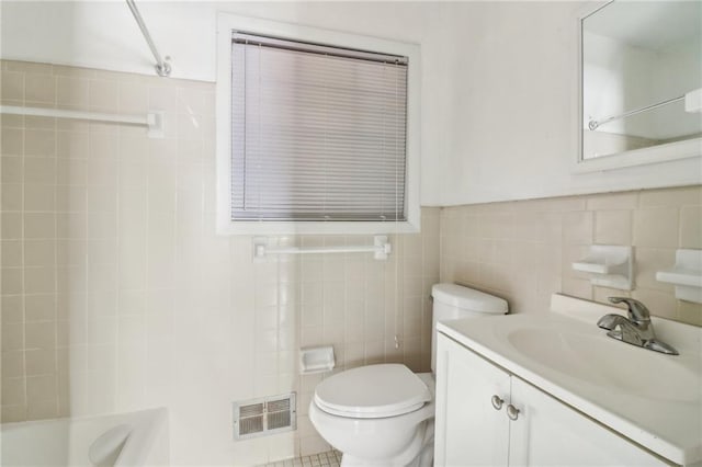 full bathroom with tile patterned flooring, toilet, shower / washtub combination, vanity, and tile walls