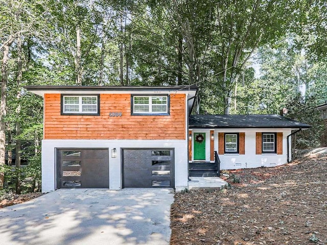 1564 Bubbling Creek Rd, Brookhaven, GA 30319 - split level home with driveway, brick siding, and an attached garage