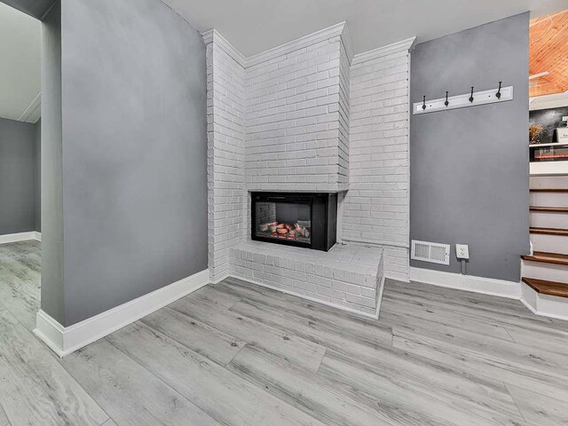 1564 Bubbling Creek Rd, Brookhaven, GA 30319 - unfurnished living room with light wood finished floors, visible vents, stairway, a brick fireplace, and baseboards