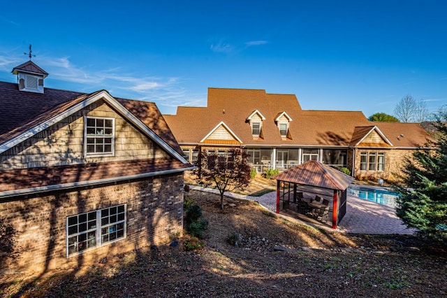 back of property with a gazebo and a sunroom