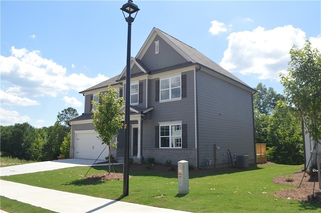 view of front facade with a front yard, cooling unit, and a garage