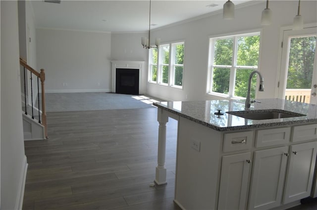 kitchen with crown molding, sink, pendant lighting, white cabinetry, and light stone counters