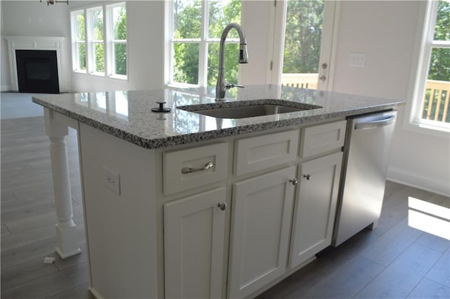 kitchen featuring sink, dishwasher, light stone countertops, and plenty of natural light