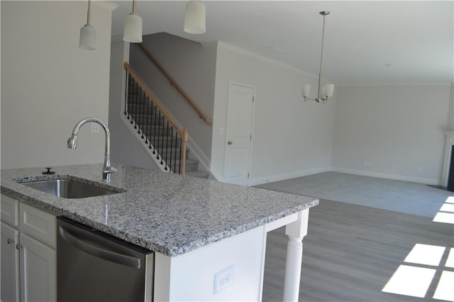 kitchen featuring sink, dishwasher, decorative light fixtures, and white cabinets