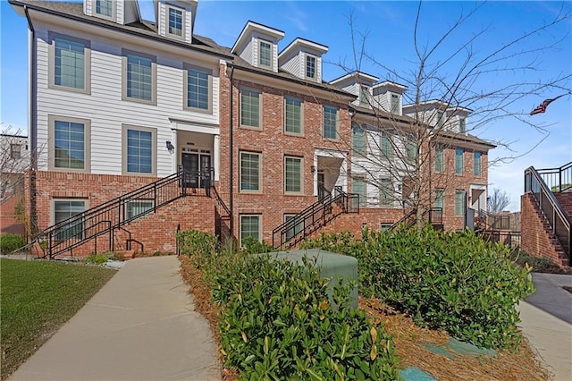 view of front of property with stairway and brick siding