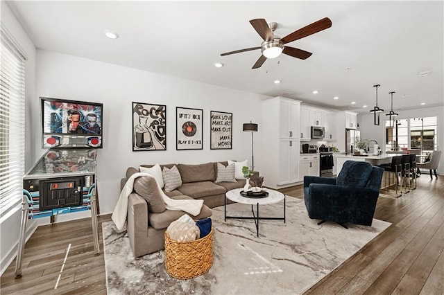 living area featuring a ceiling fan, light wood-type flooring, and recessed lighting