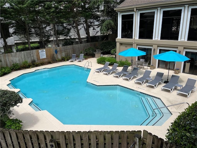 view of swimming pool with a patio and fence