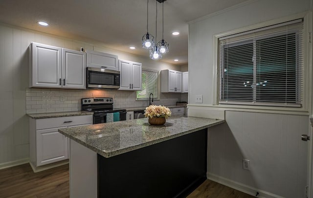 5640 Redan Cir, Stone Mountain, GA 30088 - kitchen with stainless steel microwave, range with electric cooktop, dark wood finished floors, backsplash, and light stone countertops