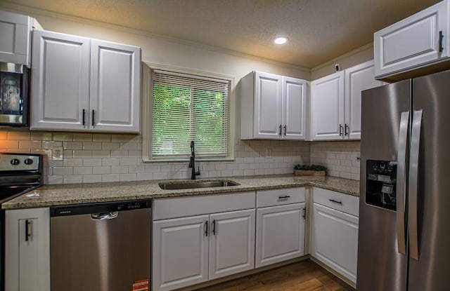 5640 Redan Cir, Stone Mountain, GA 30088 - kitchen with appliances with stainless steel finishes, a sink, crown molding, white cabinetry, and tasteful backsplash