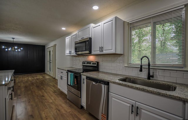 5640 Redan Cir, Stone Mountain, GA 30088 - kitchen featuring appliances with stainless steel finishes, a sink, decorative backsplash, a textured ceiling, and light stone counters