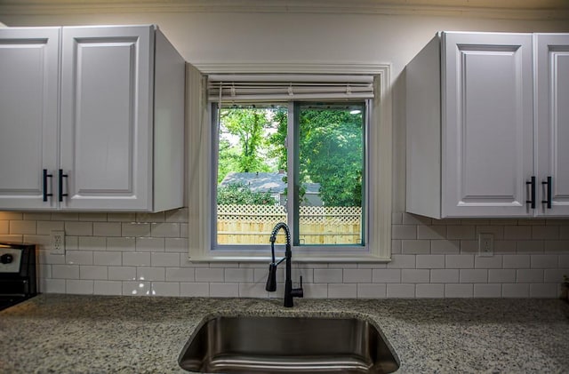 5640 Redan Cir, Stone Mountain, GA 30088 - kitchen featuring a sink, decorative backsplash, light stone countertops, and white cabinetry