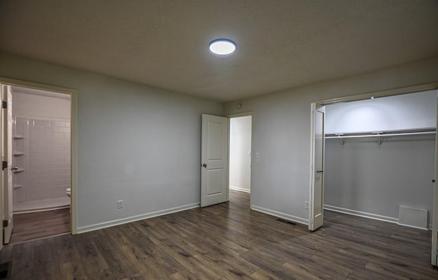 5640 Redan Cir, Stone Mountain, GA 30088 - unfurnished bedroom with baseboards, a closet, dark wood finished floors, and connected bathroom