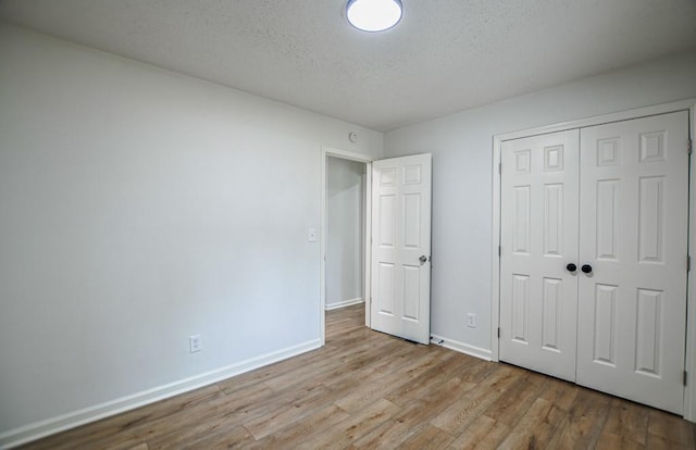 5640 Redan Cir, Stone Mountain, GA 30088 - unfurnished bedroom with wood finished floors, baseboards, a textured ceiling, and a closet