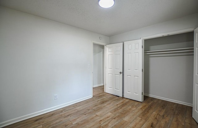 5640 Redan Cir, Stone Mountain, GA 30088 - unfurnished bedroom featuring wood finished floors, baseboards, a closet, and a textured ceiling