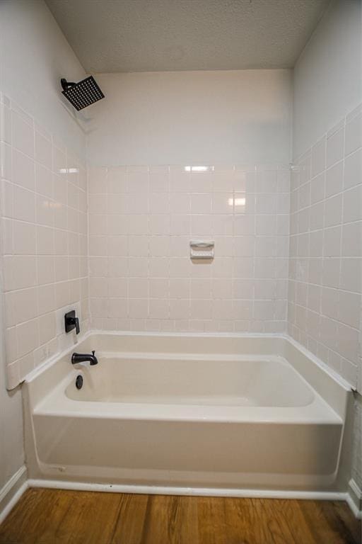 5640 Redan Cir, Stone Mountain, GA 30088 - full bath featuring wood finished floors, bathing tub / shower combination, and baseboards
