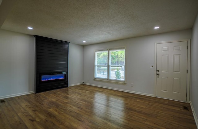 5640 Redan Cir, Stone Mountain, GA 30088 - unfurnished living room with a textured ceiling, a large fireplace, wood finished floors, recessed lighting, and baseboards