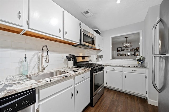 kitchen with sink, stainless steel appliances, dark hardwood / wood-style floors, decorative backsplash, and white cabinets