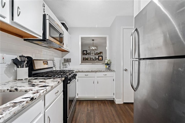 kitchen with appliances with stainless steel finishes, dark hardwood / wood-style flooring, tasteful backsplash, and white cabinetry